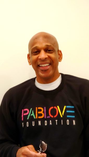 bald black man with a big friendly smile wearing a pablove foundation sweatshirt